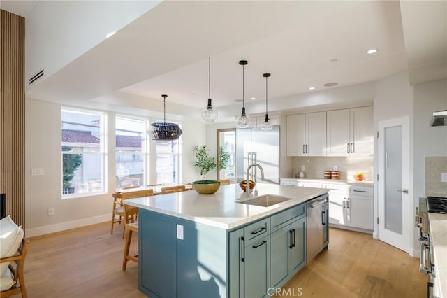 kitchen with sink, dishwasher, white cabinetry, an island with sink, and decorative light fixtures