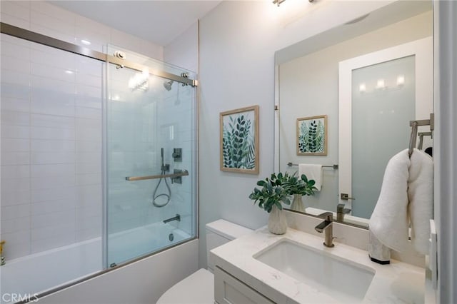 full bathroom with enclosed tub / shower combo, vanity, and toilet