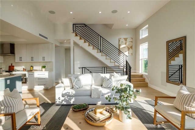 living room with a high ceiling and light hardwood / wood-style floors