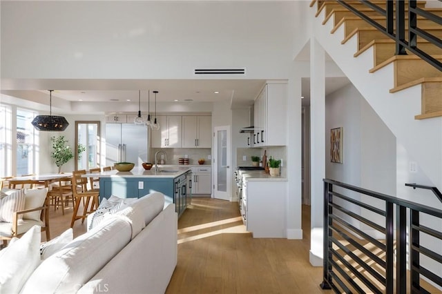 living room featuring sink and light hardwood / wood-style flooring