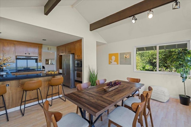 dining space featuring lofted ceiling with beams and light wood-type flooring