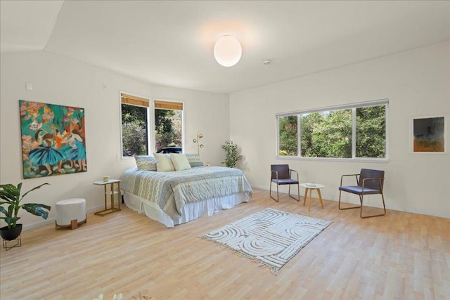 bedroom featuring lofted ceiling and light wood-type flooring