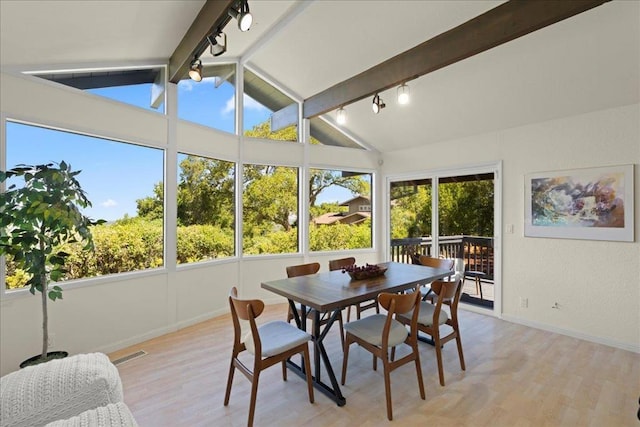 sunroom / solarium featuring track lighting and lofted ceiling with beams