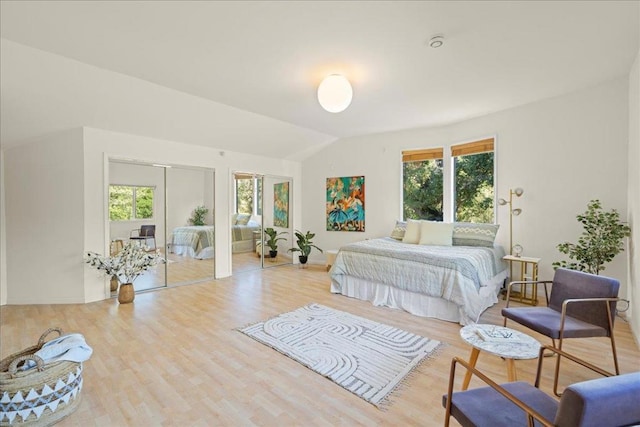 bedroom with vaulted ceiling and light hardwood / wood-style floors