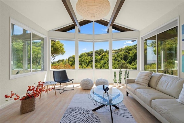 sunroom / solarium featuring vaulted ceiling with beams