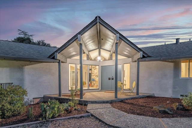 exterior entry at dusk with a patio