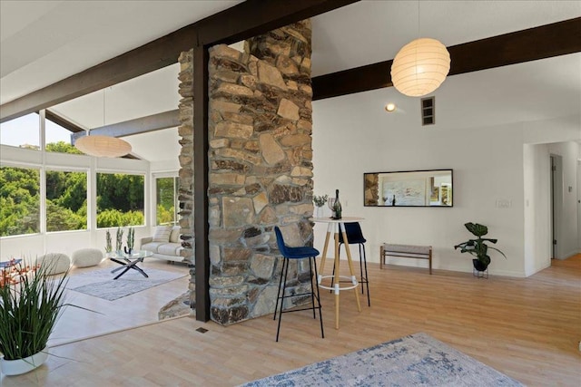 living room with lofted ceiling with beams and light wood-type flooring