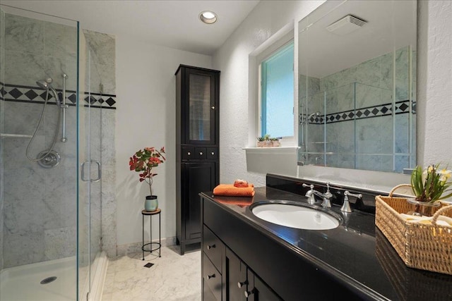 bathroom with vanity and a shower with door