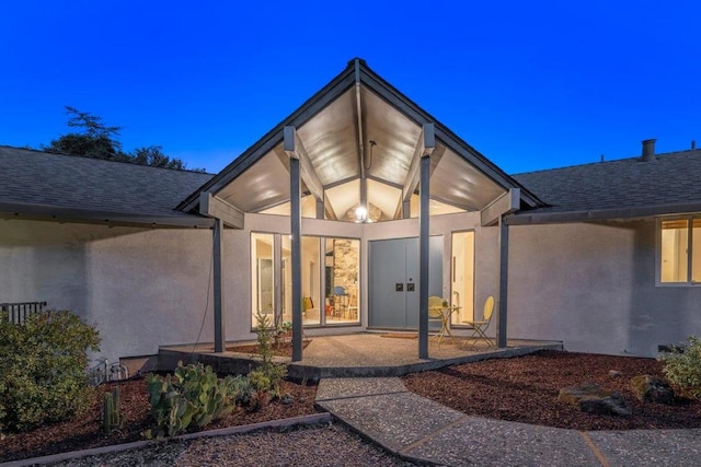 exterior entry at dusk with a patio