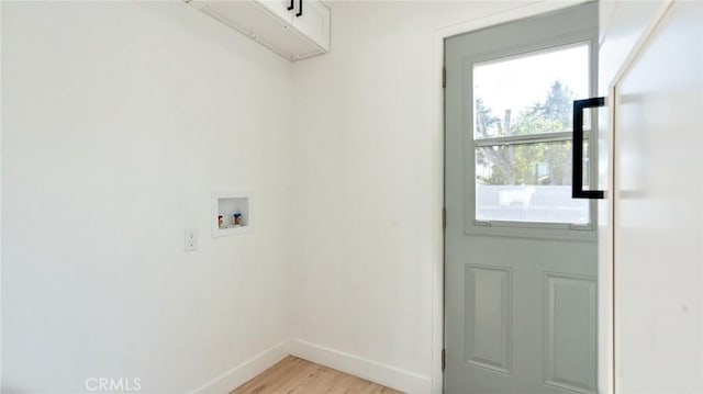 washroom featuring cabinets, hookup for a washing machine, and light wood-type flooring