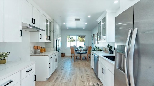 kitchen with light stone countertops, white cabinets, and appliances with stainless steel finishes