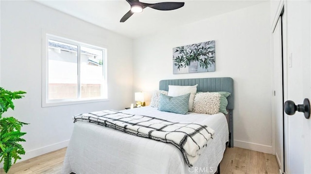 bedroom with ceiling fan, light hardwood / wood-style floors, and a closet