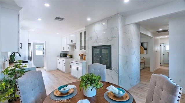 dining room featuring sink and light wood-type flooring