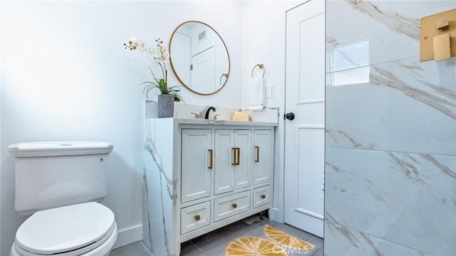 bathroom featuring vanity, tile patterned floors, and toilet