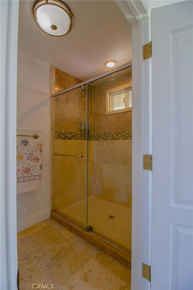 bathroom featuring a shower stall, baseboards, and tile patterned floors