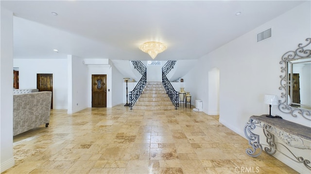 interior space with arched walkways, stone finish floor, visible vents, and stairway