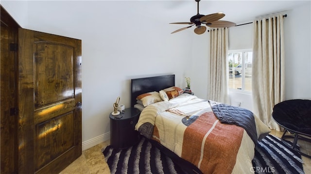 bedroom with ceiling fan and baseboards