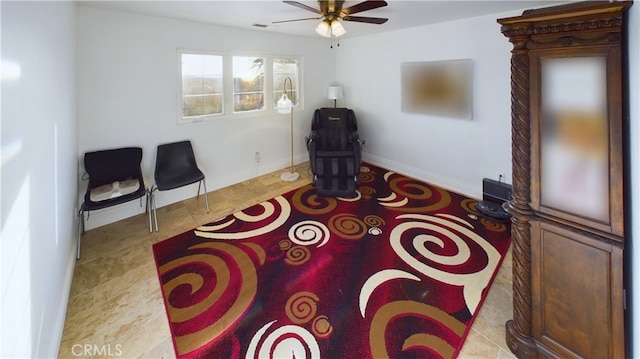 living area with ceiling fan, visible vents, and baseboards