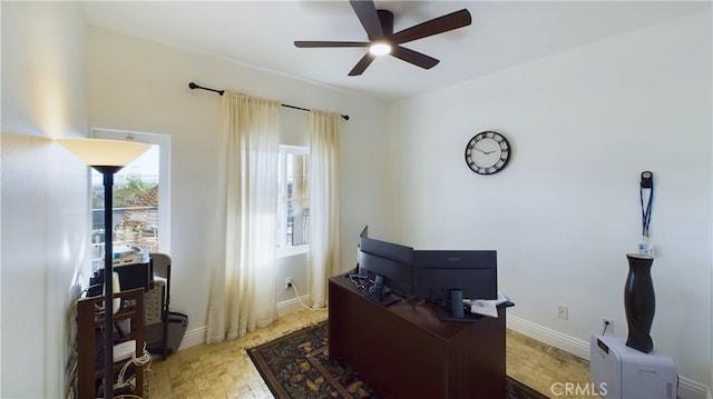 office area with a ceiling fan and baseboards