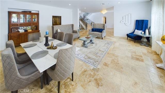 dining space with recessed lighting, stone finish flooring, baseboards, and stairs