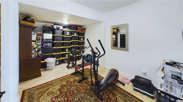 workout room featuring light tile patterned floors and baseboards