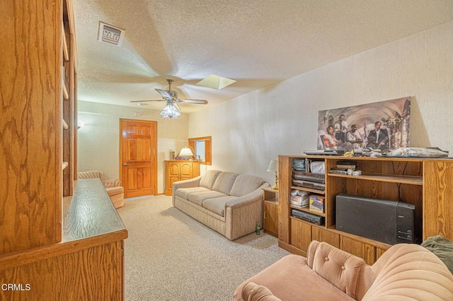 living room featuring light carpet, ceiling fan, and a textured ceiling