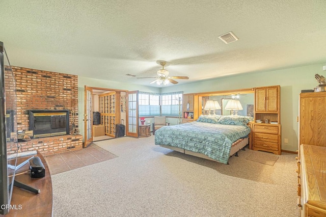 bedroom with light colored carpet, a textured ceiling, ceiling fan, and a fireplace