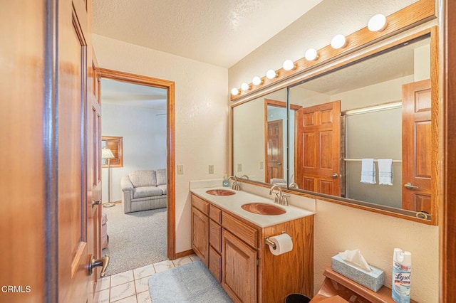 bathroom featuring walk in shower, tile patterned floors, vanity, and a textured ceiling