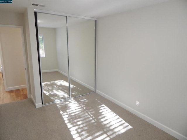 unfurnished bedroom featuring carpet flooring and a closet