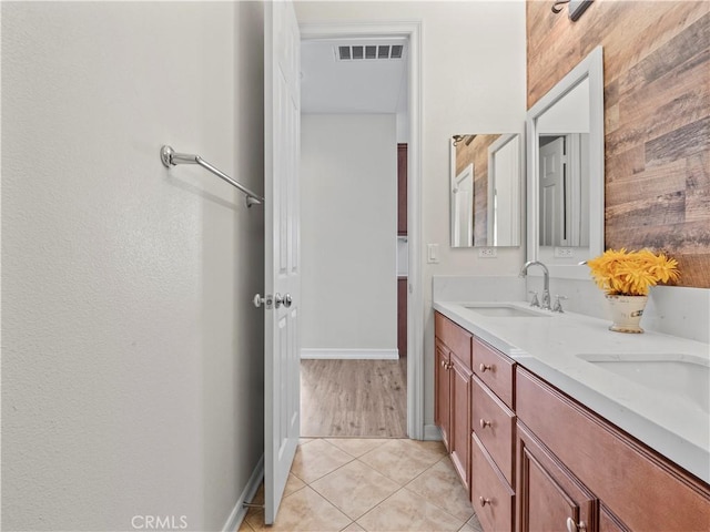 bathroom with wooden walls, tile patterned floors, and vanity