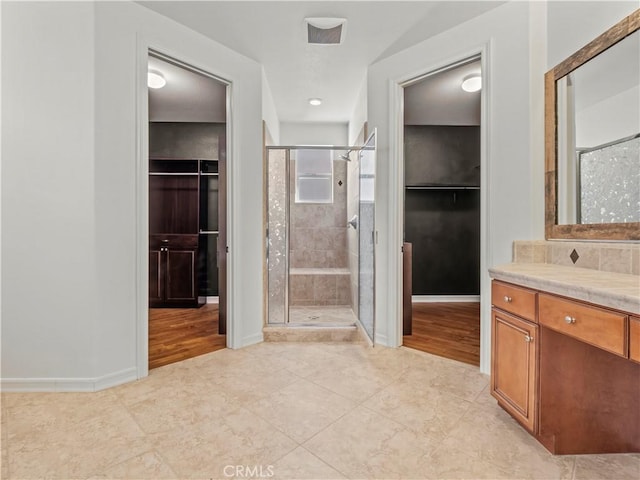 bathroom featuring vanity, tile patterned floors, and a shower with shower door