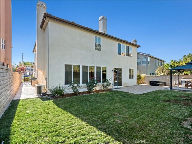 rear view of property featuring a lawn, a gazebo, a patio area, and central air condition unit