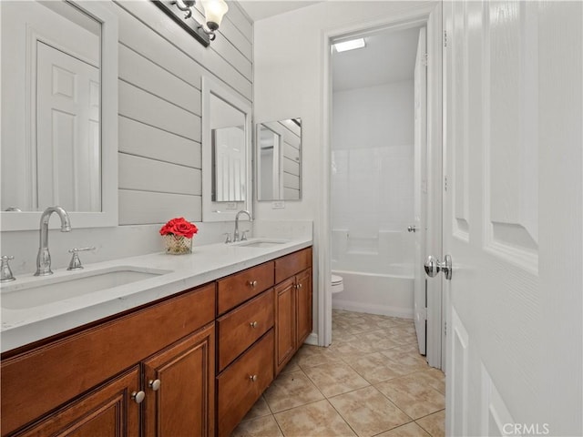 full bathroom featuring tile patterned flooring, toilet, wood walls, washtub / shower combination, and vanity