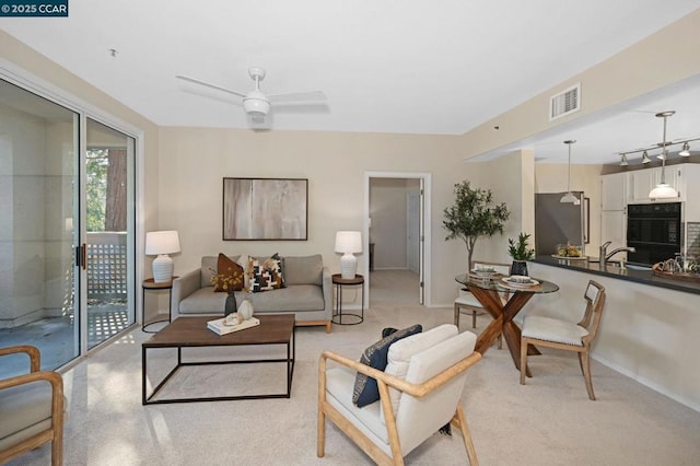 living room with ceiling fan and sink