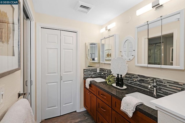 bathroom featuring hardwood / wood-style flooring, tasteful backsplash, and vanity