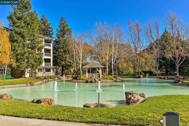 exterior space with a gazebo, a lawn, and a water view