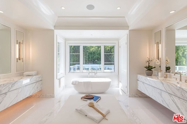 bathroom with a healthy amount of sunlight, ornamental molding, a tub to relax in, and vanity