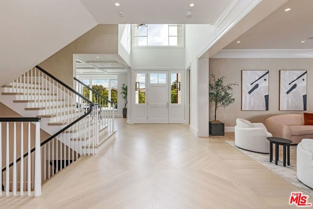 foyer entrance featuring light parquet flooring and ornamental molding