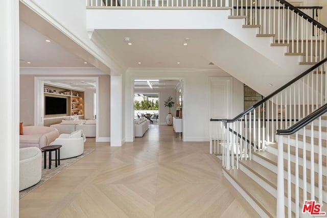 entryway featuring light parquet floors and crown molding