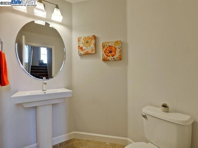 bathroom featuring toilet and tile patterned flooring