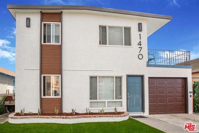 view of front facade featuring a balcony and a garage