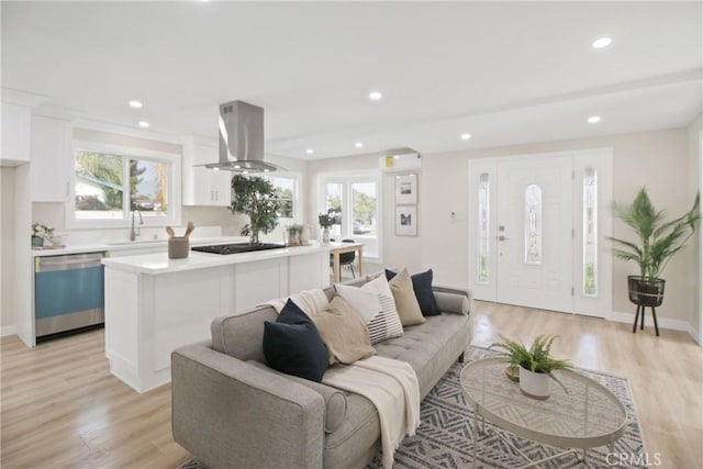 living room featuring sink, a healthy amount of sunlight, and light hardwood / wood-style floors