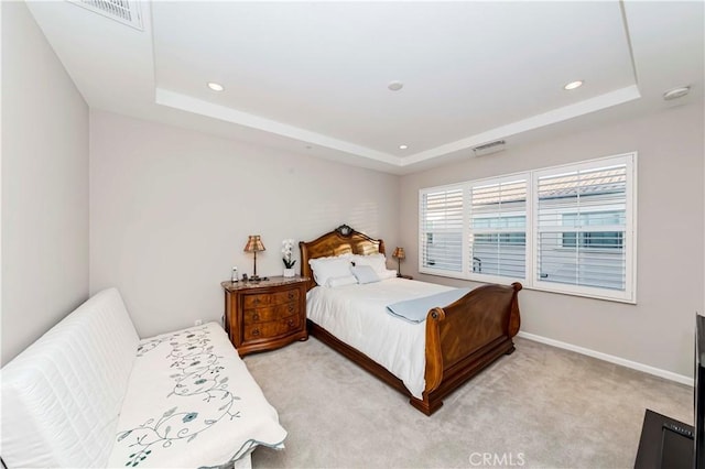 carpeted bedroom featuring a tray ceiling