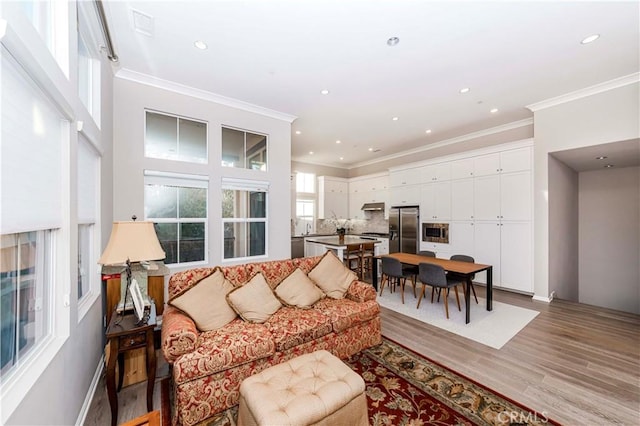 living room with light hardwood / wood-style floors and crown molding