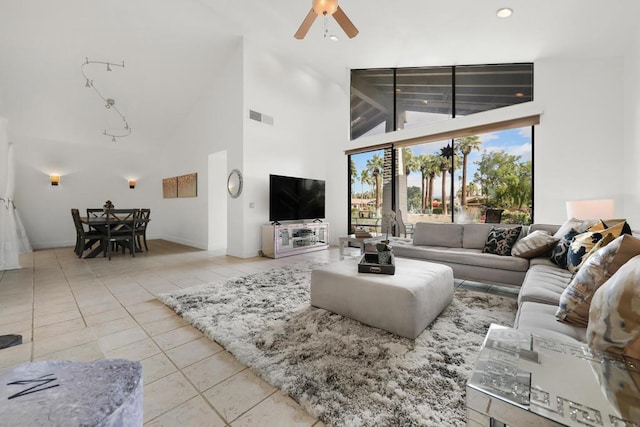 tiled living room featuring ceiling fan and high vaulted ceiling