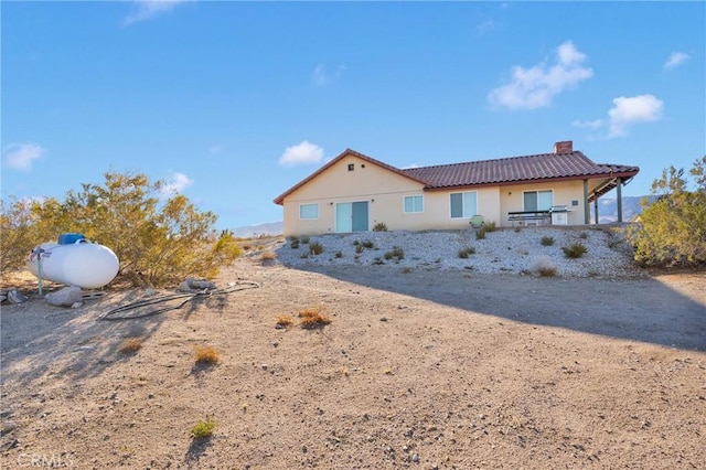 32758 Spinel Rd, Lucerne Valley, CA 92356 - view of front facade with a chimney, stucco siding, and a tiled roof