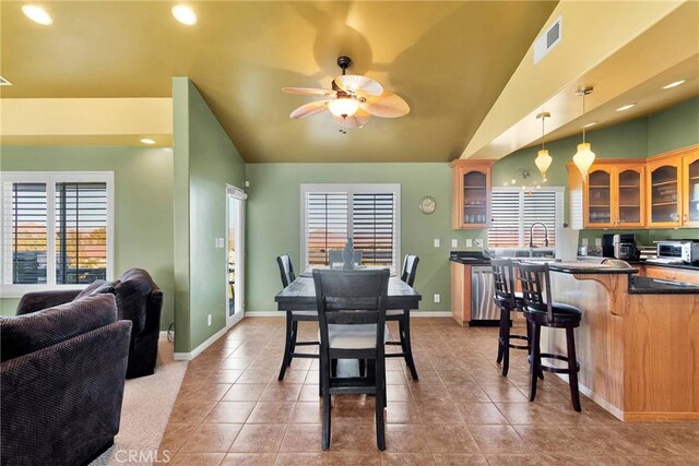 tiled dining area featuring vaulted ceiling, ceiling fan, and sink