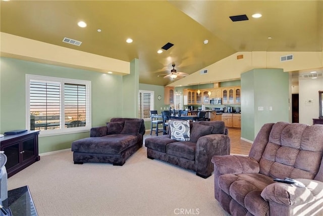 living room with ceiling fan, light colored carpet, and vaulted ceiling