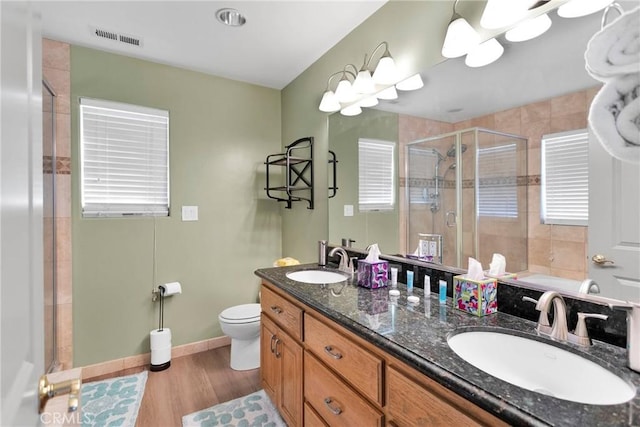 bathroom featuring toilet, hardwood / wood-style flooring, an enclosed shower, and vanity