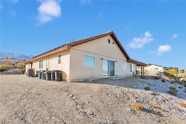 back of property with cooling unit and a mountain view